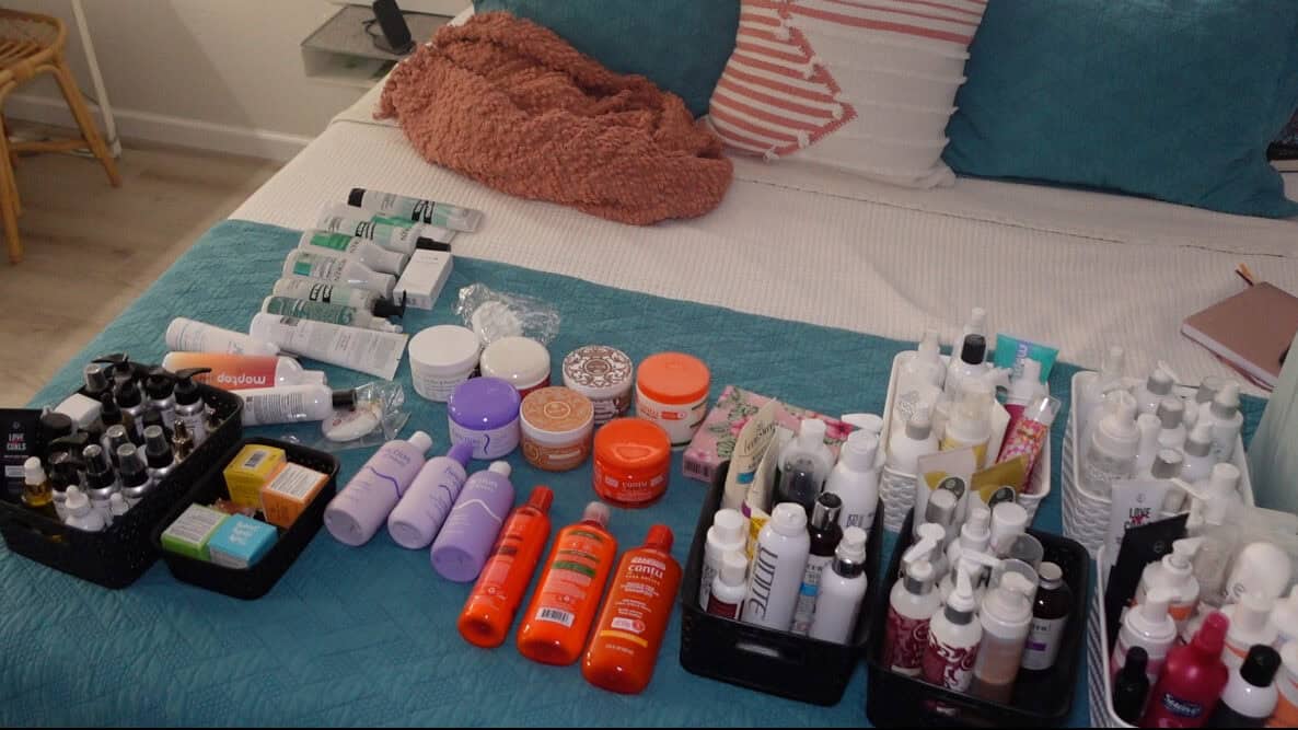 Lockiges Haarprodukt Versteck alles auf einem Bett, um zu deklotieren